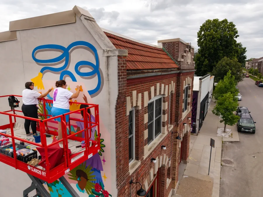 Teya y Marissa Hernandez pintan un mural en Nos Books, en Des Moines