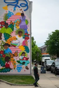 Una persona camina frente al mural de Marissa Hernandez en Nos Books, en Des Moines