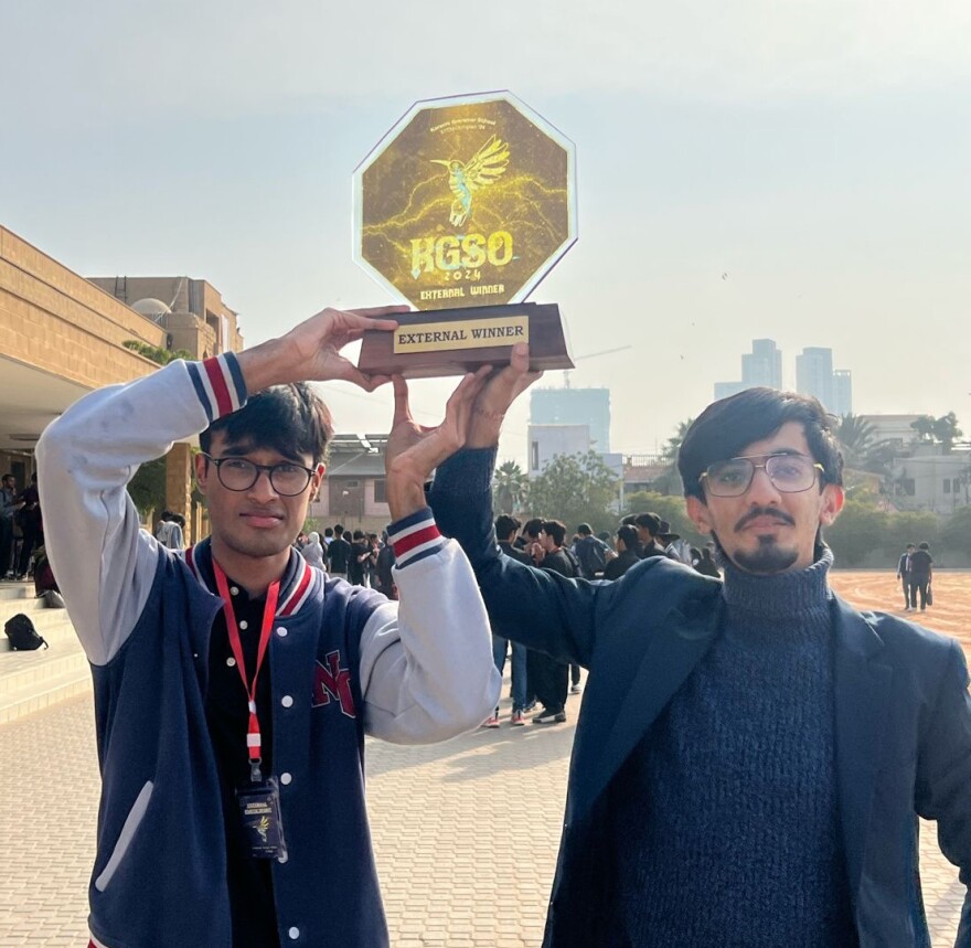 Daniyal Shahbaz y un compañero sostienen un trofeo tras ganar una competencia científica en Pakistán en 2024.