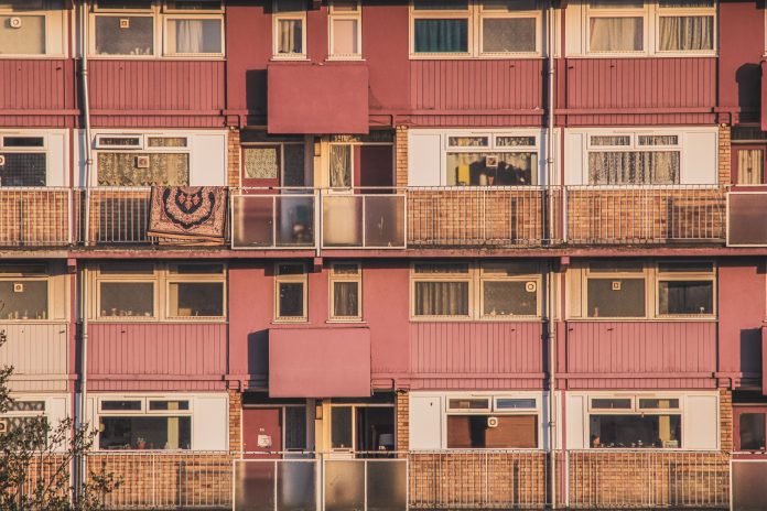 pexels-lebele-12375185 Exterior of a multi-story apartment building with balconies and windows.