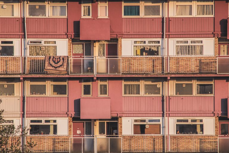 Exterior of a multi-story apartment building with balconies and windows.