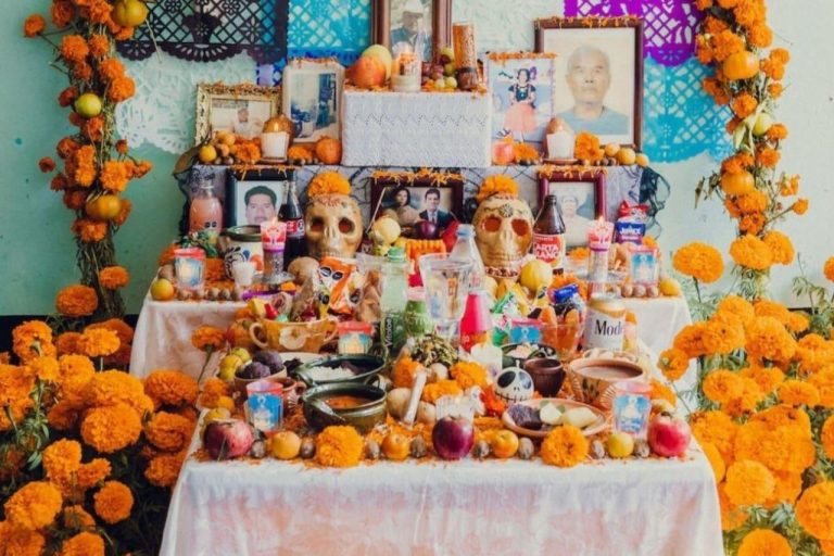 Traditional Día de Muertos ofrenda with photographs and offerings honoring deceased loved ones.
